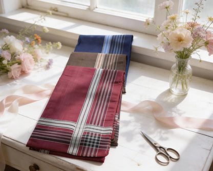 Folded fabric with plaid pattern on a table with flowers and scissors