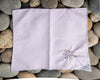 Folded purple handkerchief with floral embroidery on pebbles