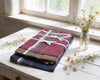 Folded fabric bundles on a wooden surface with flowers around