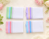 Four folded hanky with colorful stripes on a light background with flowers.
