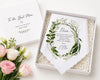 Gift box with a personalized towel and flowers on a white background