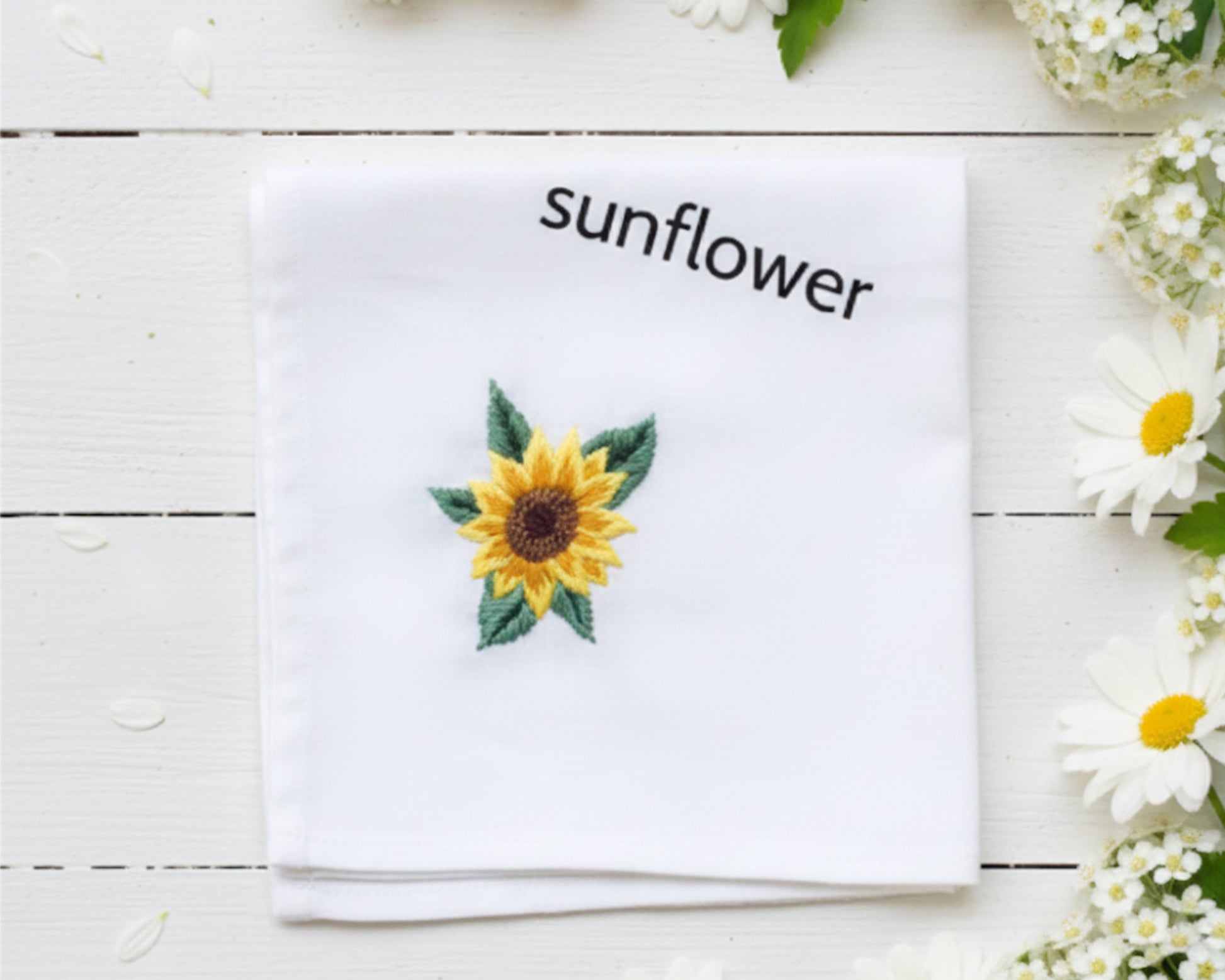 Square white cotton handkerchief showcasing a detailed yellow sunflower embroidery framed by white daisy petals