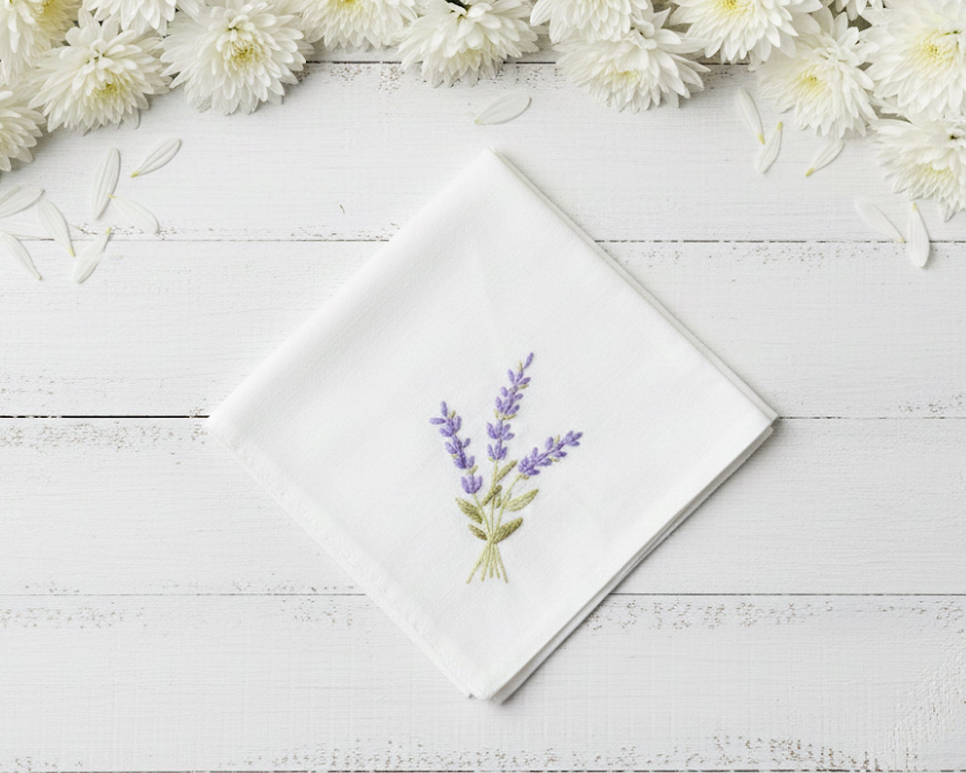 Pure white cotton handkerchief featuring centered violet lavender embroidery with green foliage on a light wood backdrop