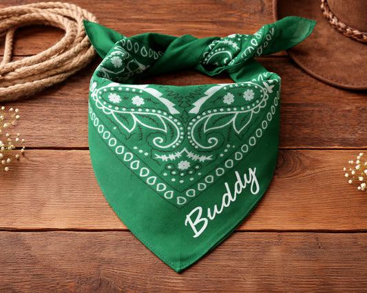 Green bandana with 'Buddy' printed on it on a wooden surface