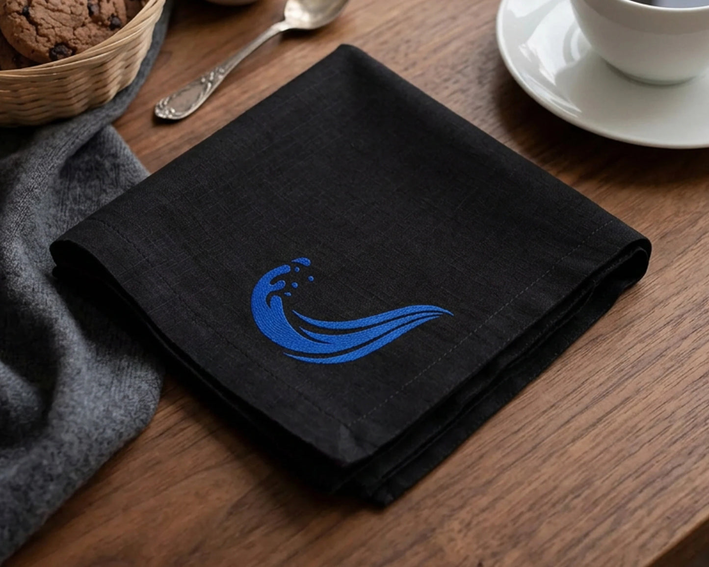 Green hankie with 'Free to Sparkle' text on a table with a cup of coffee and cookies.