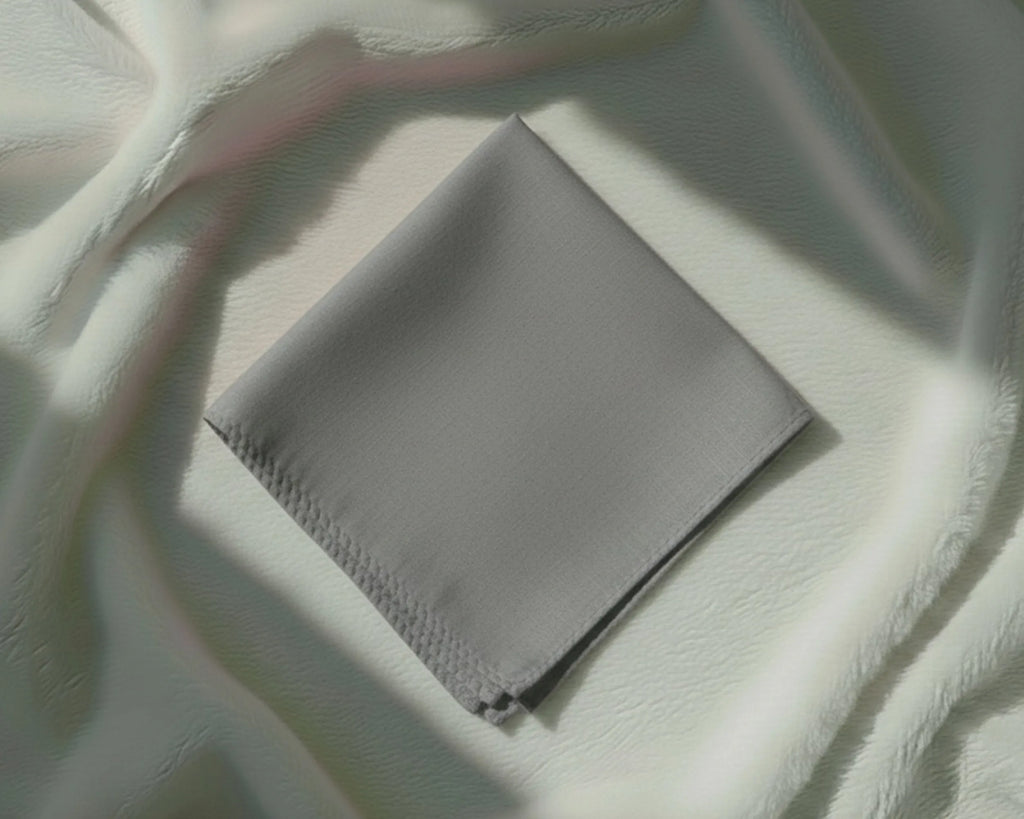 Gray fabric pouch on a textured white surface