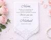 Handkerchief with a message to 'Mom' surrounded by pink roses on a textured surface.