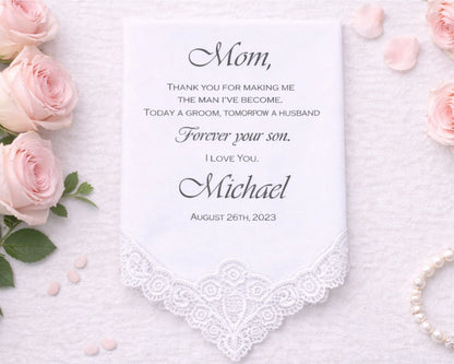 Handkerchief with a message to 'Mom' surrounded by pink roses on a textured surface.