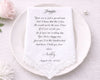 Handkerchief with a personalized message on a white plate, surrounded by flowers.