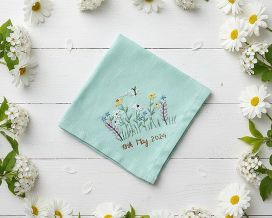 Mint green cotton handkerchief decorated with a colorful embroidered meadow scene and custom 2024 date