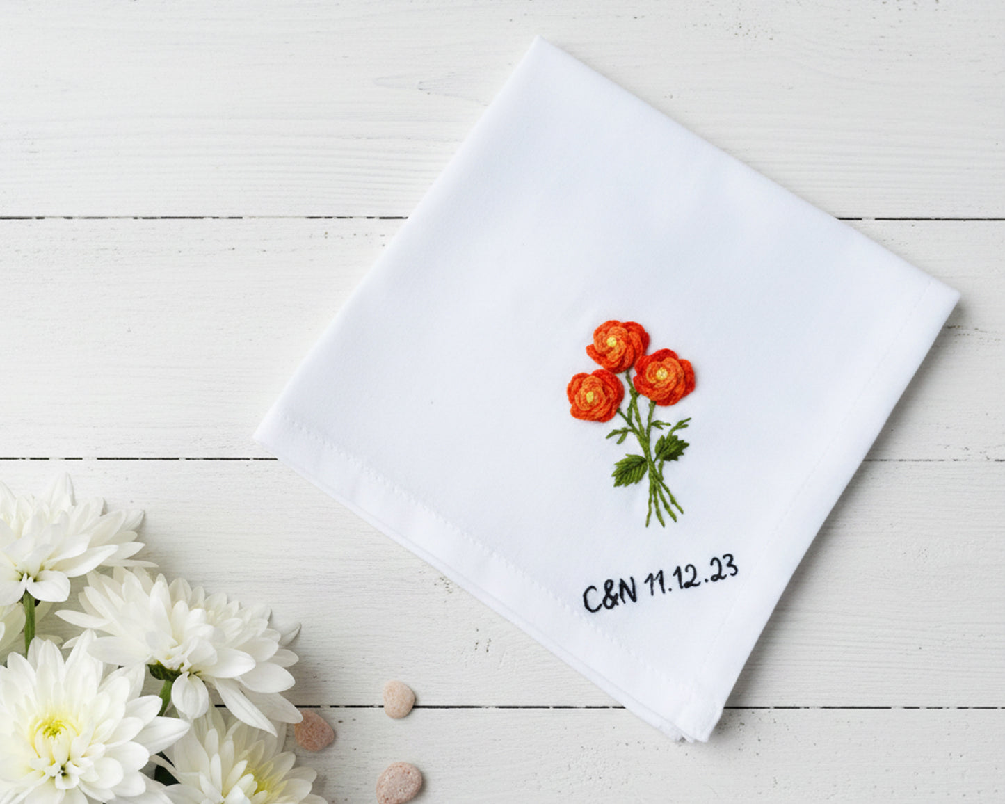 White cotton handkerchief decorated with orange poppy needlework and personalized black text and date