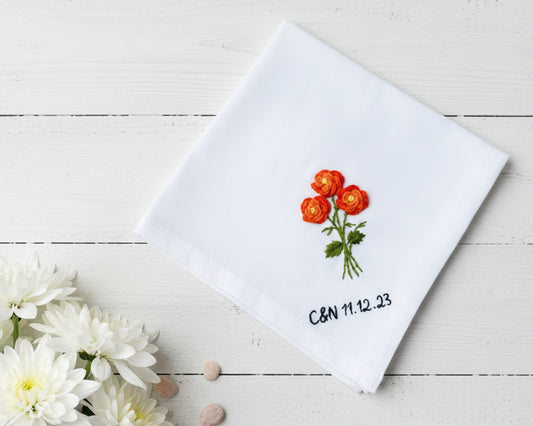 White cotton handkerchief decorated with orange poppy needlework and personalized black text and date