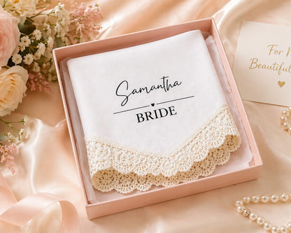 Lace handkerchief with 'Samantha BRIDE' text in a pink box with flowers and jewelry in the background