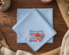 Light blue hanky with a printed design on a wooden surface
