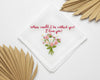 White cotton handkerchief decorated with a pink and white wildflower bouquet and sentimental red script embroidery