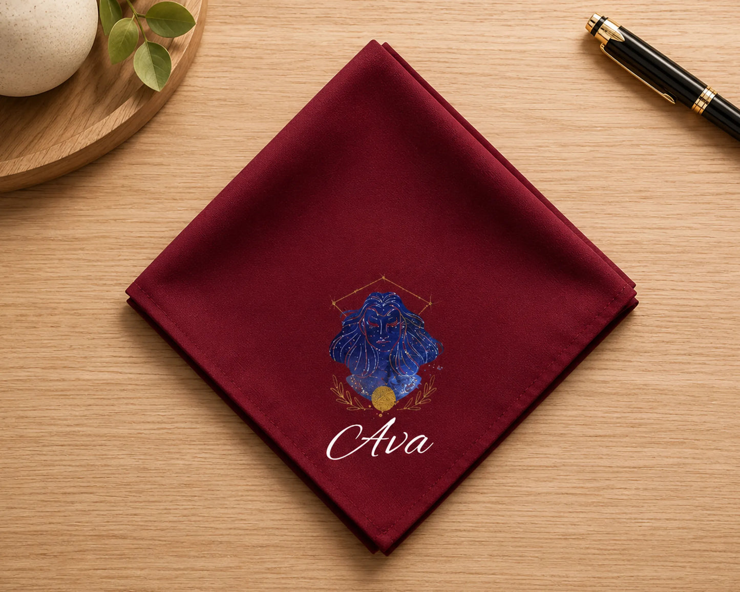Maroon pocket square with blue floral design and 'Ava' text on a wooden surface.