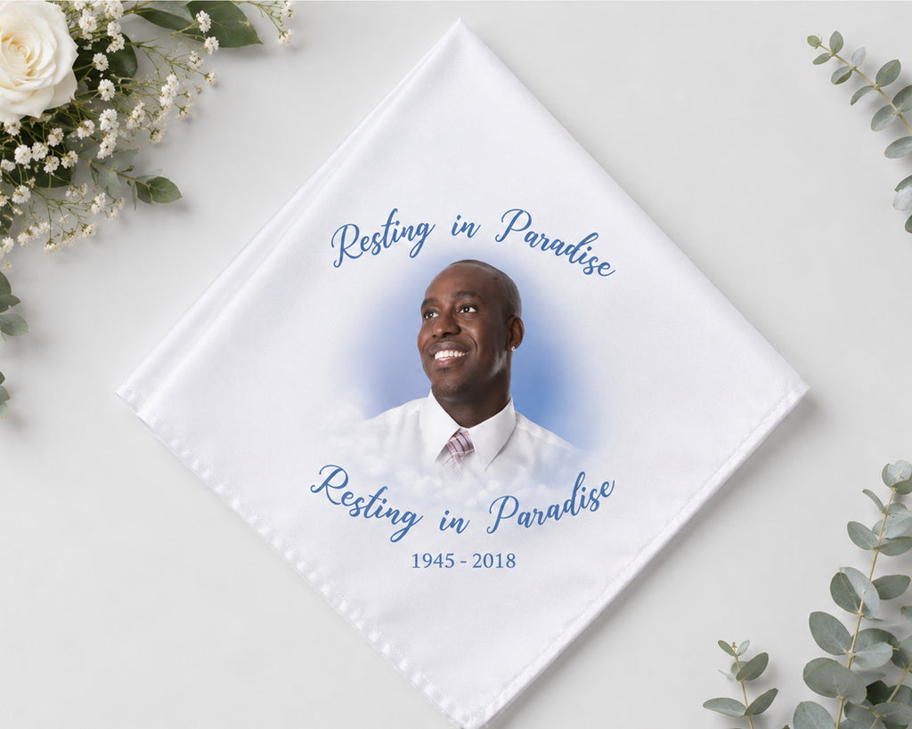 Memorial hnaky with a photo of a man and 'Resting in Paradise' text on a white background with flowers.