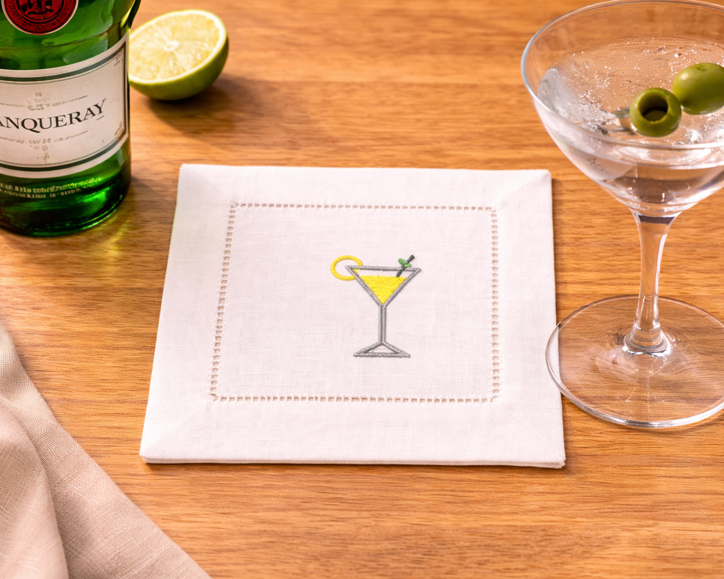 Napkin with cocktail illustration, bottle of Martini, and glass on wooden surface