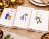 Napkins with embroidered designs of palm trees, stars, and buildings on a decorative table setting.