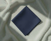 Navy blue fabric square on a textured white surface