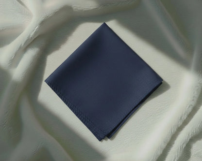 Navy blue fabric square on a textured white surface