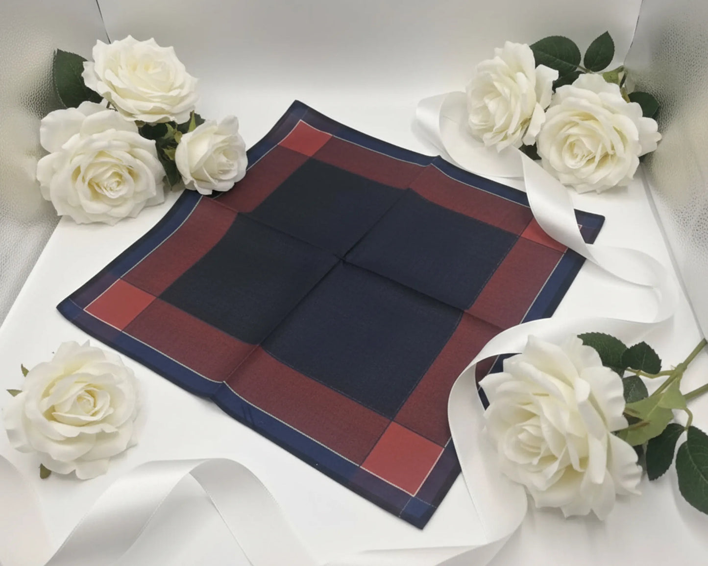 Navy and red plaid fabric with white roses on a white background