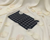 Navy blue checkered fabric on a white fabric background with scattered rose petals