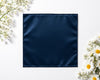 Navy blue fabric square surrounded by white flowers on a light background