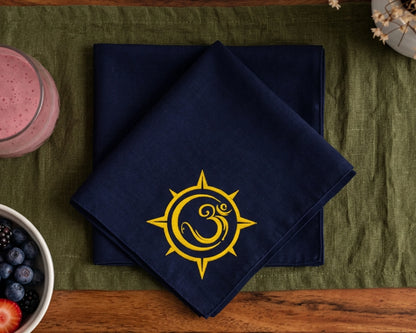 Navy blue hanky with a yellow sun and moon symbol on a green tablecloth.