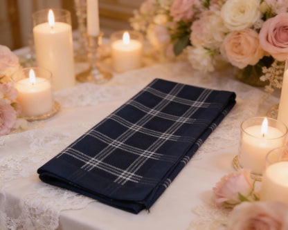 Navy plaid hanky on a table with candles and flowers