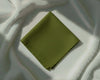 Green fabric square on a textured white surface
