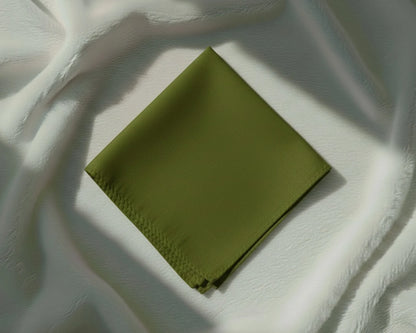 Green fabric square on a textured white surface