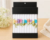 Pack of colorful flowers on a wooden surface with a light background
