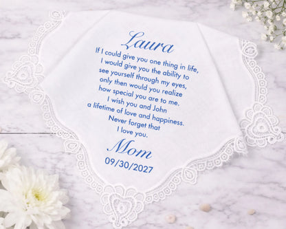 Personalized handkerchief with a message from 'Mom' to 'Laura' on a marble surface with flowers.
