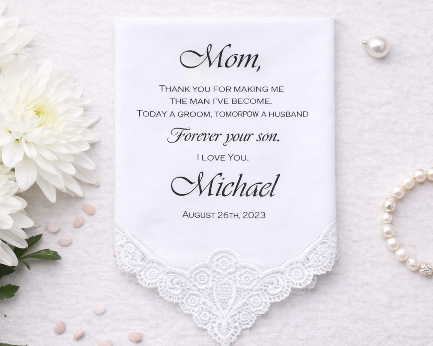 Personalized handkerchief with a message to 'Mom' on a white background with flowers and pearls.