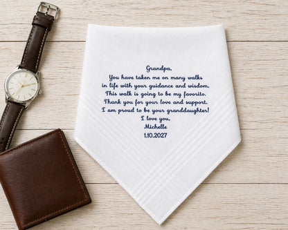 Personalized handkerchief with a message to a grandpa, placed next to a watch and wallet on a wooden surface.