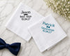 Personalized hanky for a wedding with names and dates embroided on them, placed on a marble surface with a bow tie.