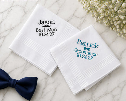 Personalized hanky for a wedding with names and dates embroided on them, placed on a marble surface with a bow tie.