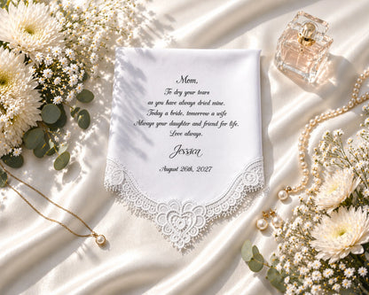 Personalized hanky with lace detailing, flowers, and jewelry on a white fabric background