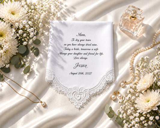 Personalized hanky with lace detailing, flowers, and jewelry on a white fabric background
