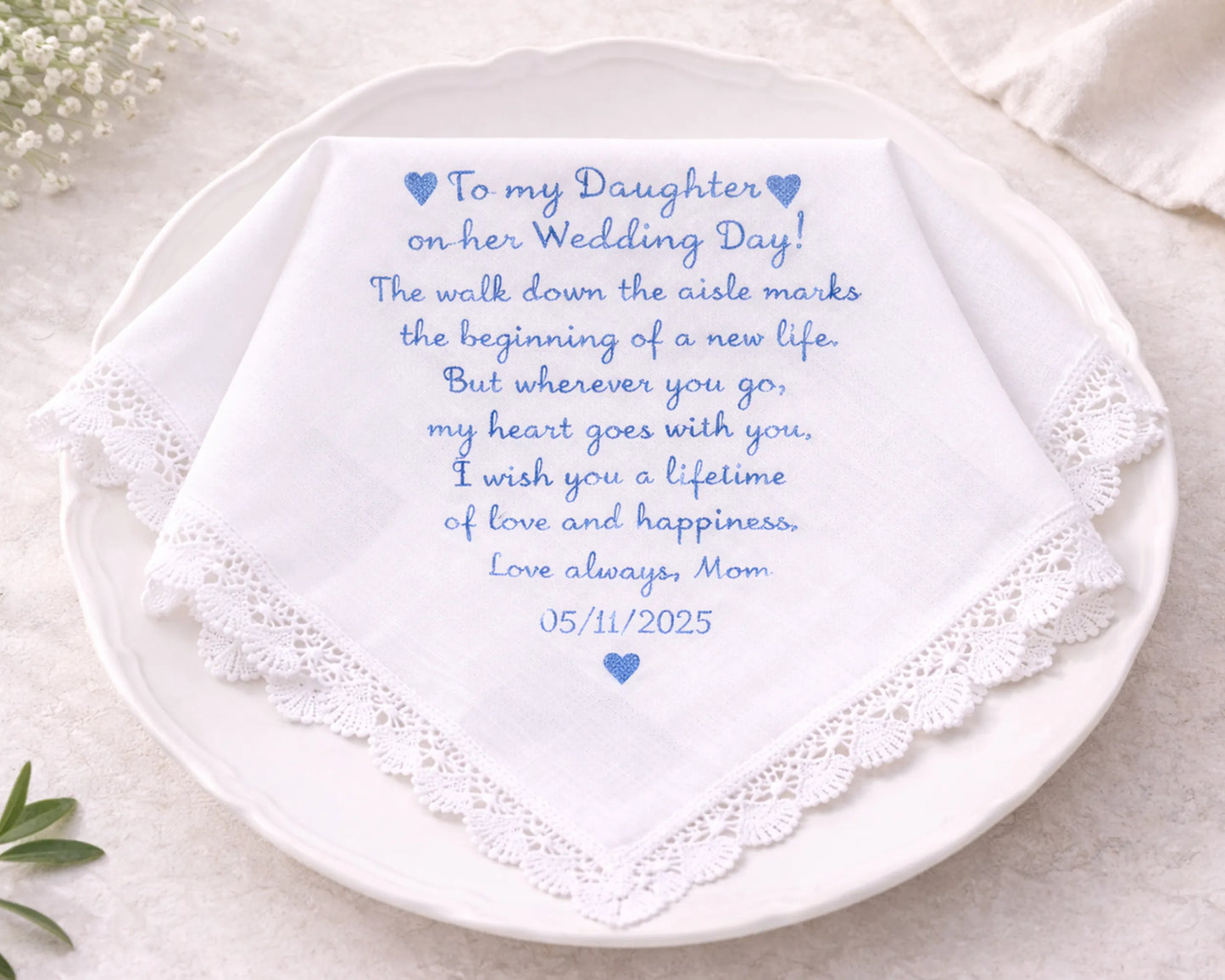Personalized wedding handkerchief with embroidered message on a white plate.