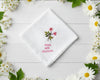 Personalized white cotton handkerchief with delicate pink floral needlework and custom red date embroidery framed by daisies