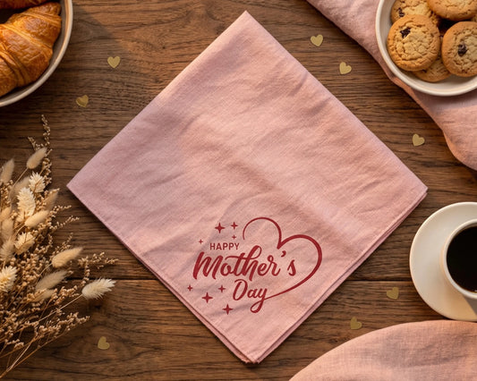 Pink hanky with 'Happy Mother's Day' text on a wooden table with coffee, cookies, and flowers.