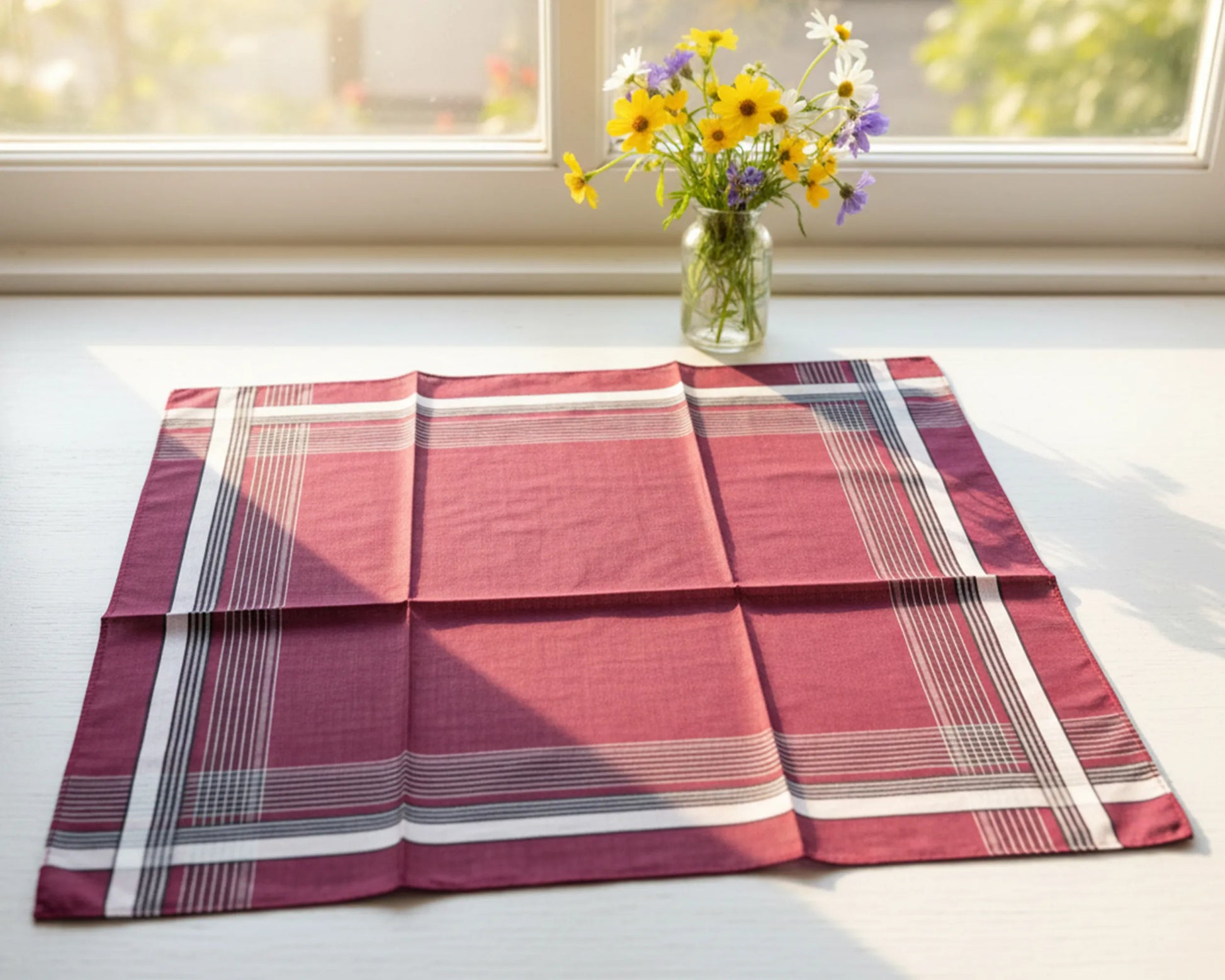 Plaid tablecloth on a table with a vase of flowers in the background