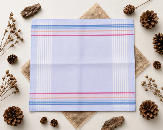 Plaid fabric with colorful stripes on a light background with decorative elements like pine cones and twigs.