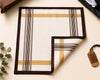 Plaid patterned product on a light surface with a plant and leather item in the background