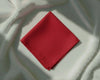 Red fabric square on a textured white background