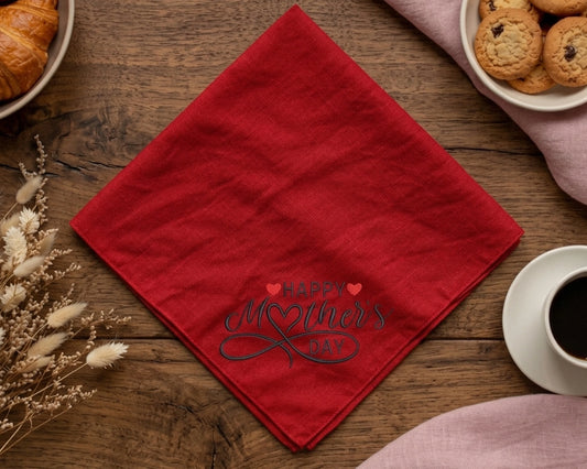 Red hanky with 'Happy Mother's Day' text on a wooden table with coffee and cookies.