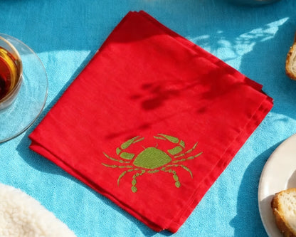 Red hanky with a green crab design on a blue tablecloth