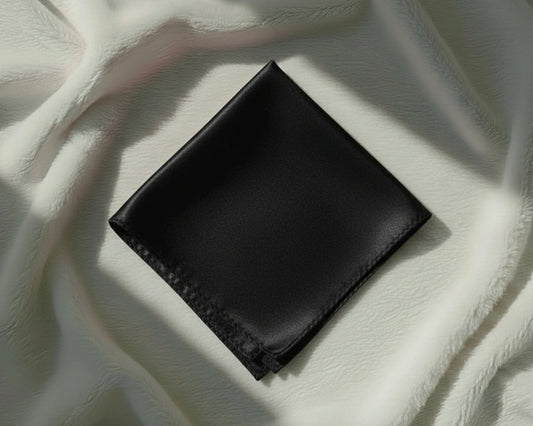 Black leather wallet on a light fabric background